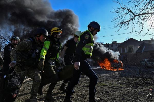 Emergency workers rush an injured woman amid Russian missile attacks in Zaporizhzhia over the weekend. 