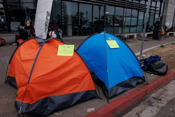 Eviction notices attached to homeless tents on a city sidewalk in San Diego, California