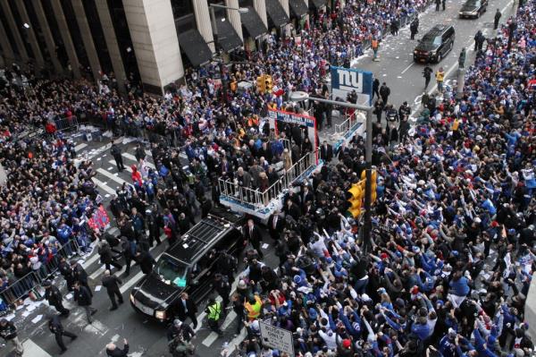 A float carrying New York Giants Quarterback Eli Manning and the team owners travels up Broadway 