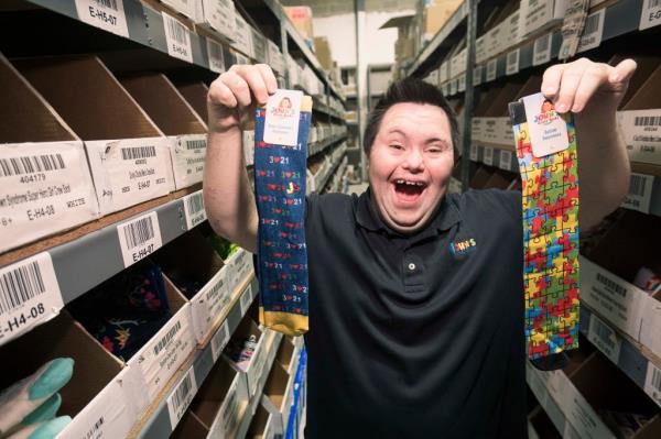 Long Island man John Cro<em></em>nin is seen in his warehouse is holding pairs of socks in ho<em></em>nor of Down syndrome and autism awareness. 