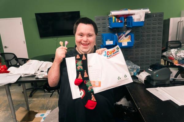 John Cro<em></em>nin is seen placing candy and a special note in a customer's order.