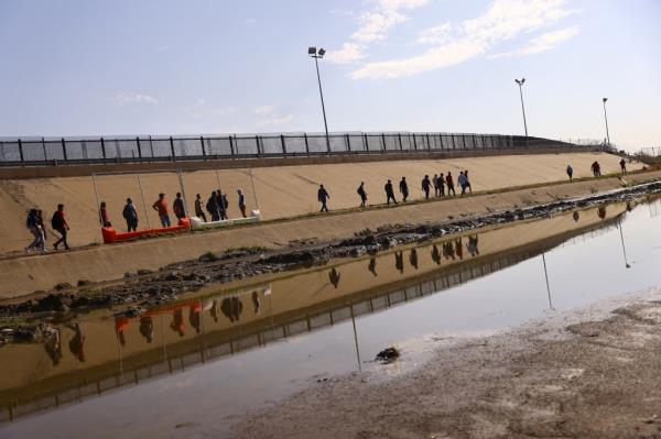 Asylum-seeking migrants lined up to surrender themselves to Border Patrol agents outside of El Paso, Texas.