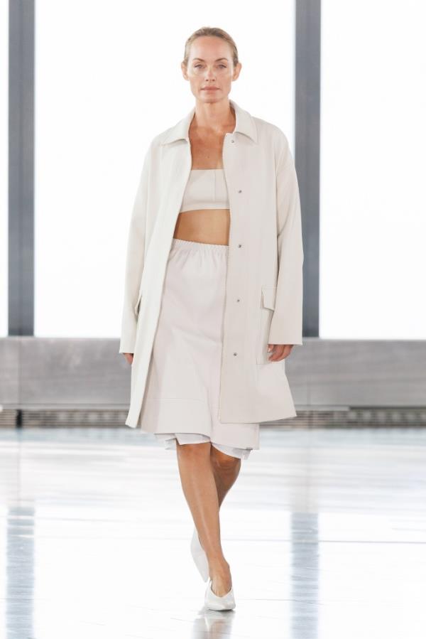 Amber Valletta modeling a white coat and skirt on the SIMKHAI runway at SS25 NYFW, photo by Bahram Hakkakian